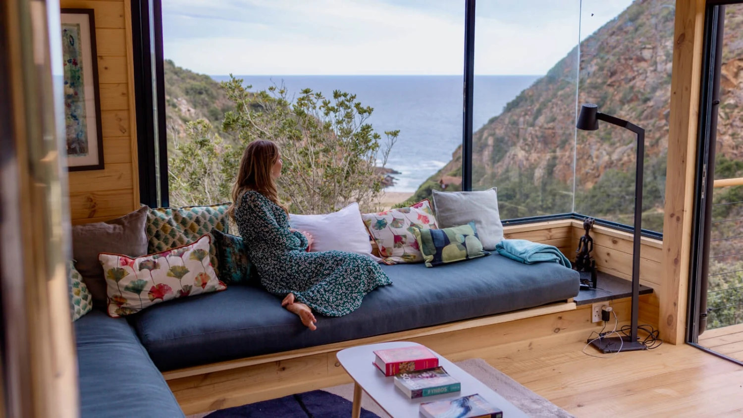 Guest relaxing on a window seat overlooking the Indian Ocean at a secluded Garden Route holiday house